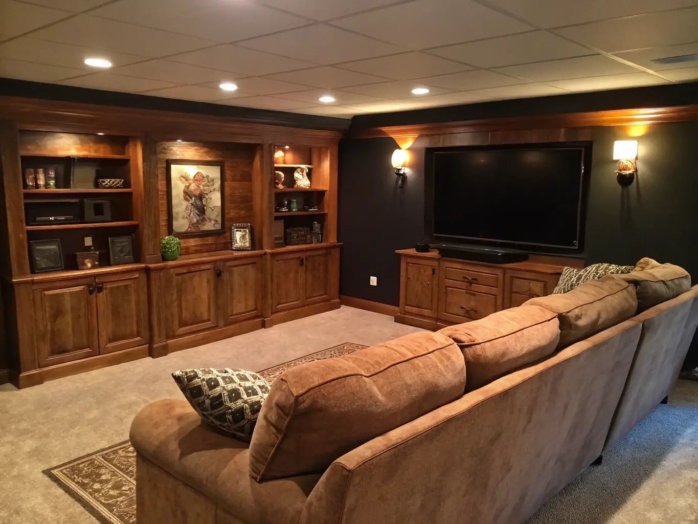 A cozy and stylish finished basement featuring a home theater setup, comfortable seating, and modern lighting, illustrating Krew Home Remodeling's basement finishing capabilities.